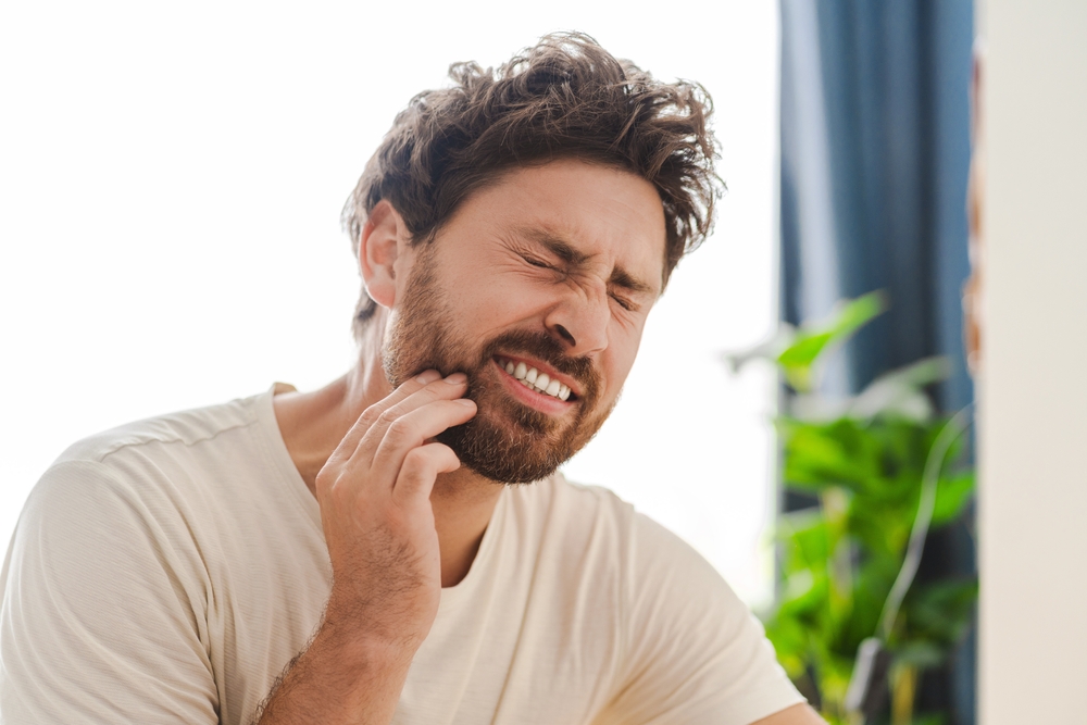 Man experiencing tooth pain for the Emergency Dentistry page of Niral A. Patel DDS