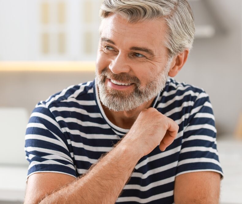 A portrait of a smiling man wearing a striped shirt