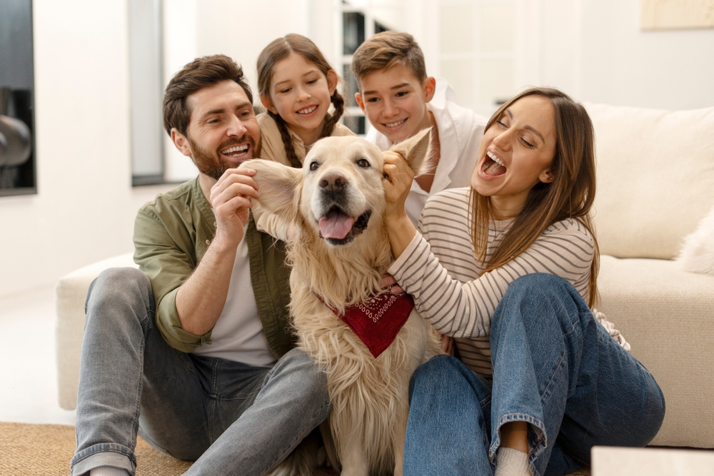 A picture of a family playing with a dog
